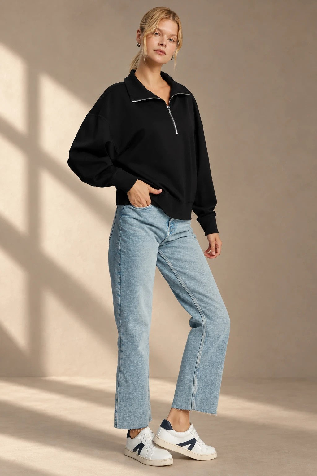 Woman in a black half-zip sweatshirt